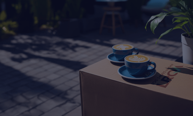 Two coffee cups on an LRQA branded box